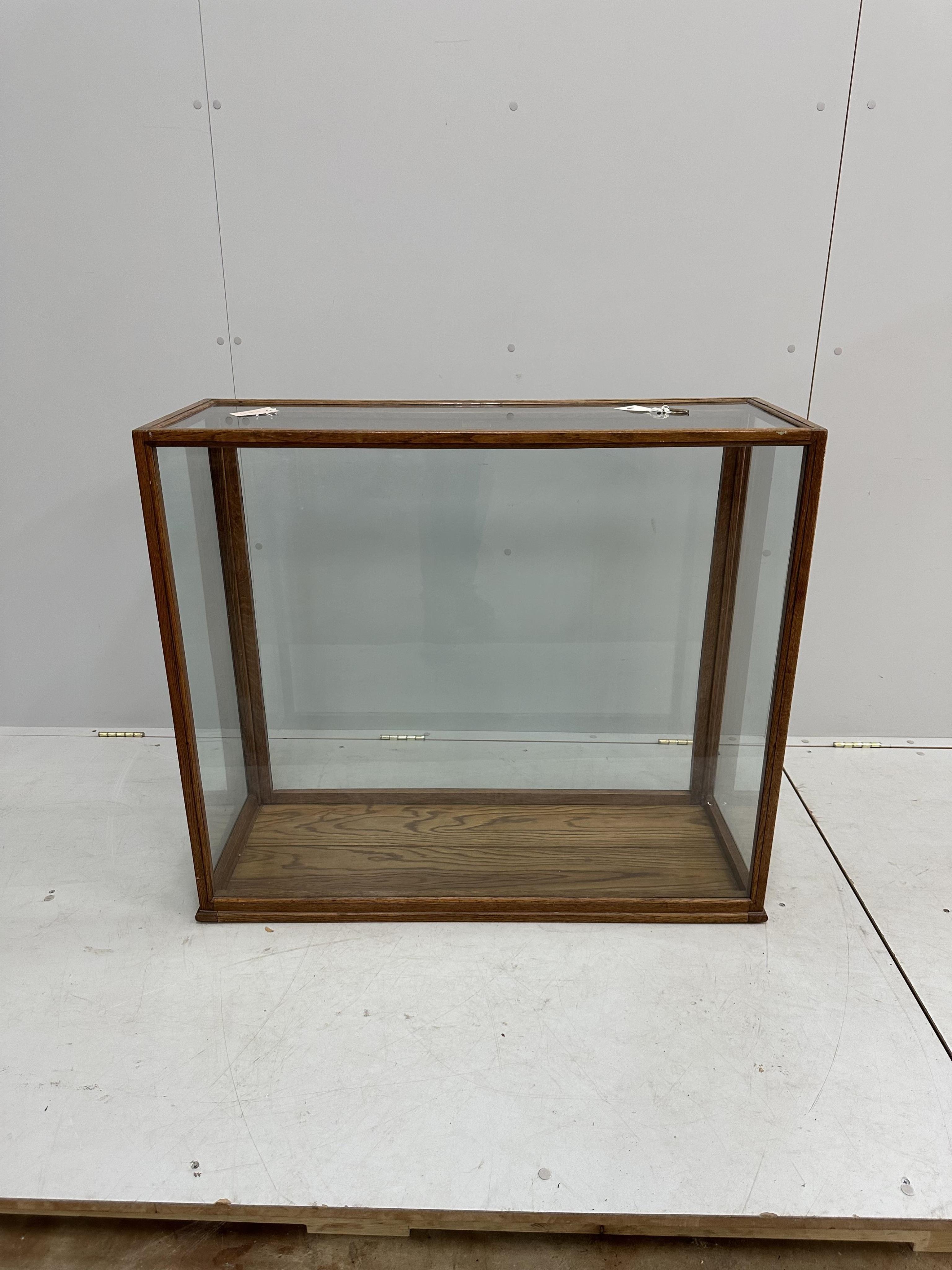 An early 20th century glazed oak display case, width 96cm, depth 35cm, height 83cm. Condition - fair